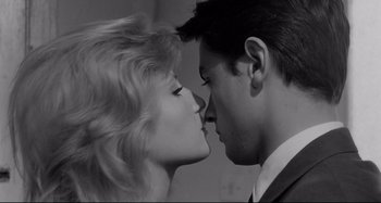 Movie still from “L'Eclisse” (1962), directed by Michelangelo Antonioni – A black and white photo of a man and a woman kissing; Close Up shot, Low angle