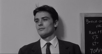 Movie still from “L'Eclisse” (1962), directed by Michelangelo Antonioni – Black and white photograph of a man in a suit and tie; Close Up shot, Low angle