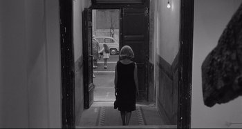 Movie still from “L'Eclisse” (1962), directed by Michelangelo Antonioni – A woman walking down the stairs of a building; Wide shot, Over the shoulder angle
