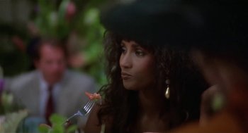 Movie still from “L.A. Story” (1991), directed by Mick Jackson – A person holding a fork in their mouth; Close Up shot, Over the shoulder angle