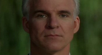 Movie still from “L.A. Story” (1991), directed by Mick Jackson – A man's face in front of a green background; Close Up shot, Low angle