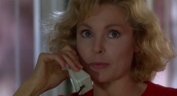 Movie still from “L.A. Story” (1991), directed by Mick Jackson – A woman is talking on a phone and looking at the camera; Close Up shot, Low angle