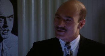 Movie still from “L.A. Story” (1991), directed by Mick Jackson – A man in a suit and tie is smiling for the camera; Close Up shot, Low angle