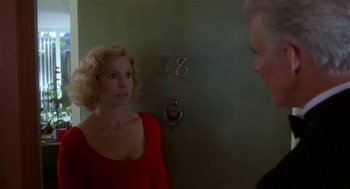 Movie still from “L.A. Story” (1991), directed by Mick Jackson – A woman in a red dress talking to a man in a black shirt; Medium shot, Over the shoulder angle