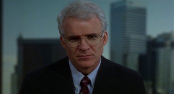Movie still from “L.A. Story” (1991), directed by Mick Jackson – An older man wearing a suit and tie; Close Up shot, Over the shoulder angle