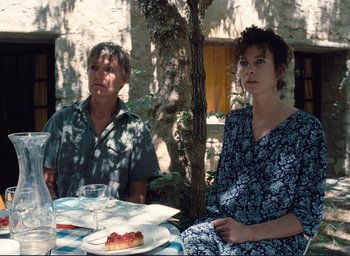 Movie still from “La Belle Noiseuse” (1991), directed by Jacques Rivette – A man and a woman sitting at a table with food; Medium shot, High angle