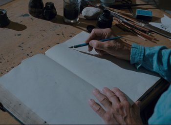 Movie still from “La Belle Noiseuse” (1991), directed by Jacques Rivette – A person writing on a piece of white paper; Extreme Close Up shot, Overhead angle