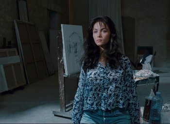 Movie still from “La Belle Noiseuse” (1991), directed by Jacques Rivette – A woman standing in front of an easel in an art studio; Medium shot, Low angle