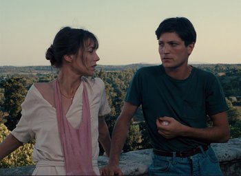 Movie still from “La Belle Noiseuse” (1991), directed by Jacques Rivette – A man and a woman standing next to each other; Medium shot, Low angle