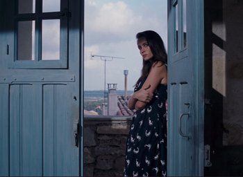 Movie still from “La Belle Noiseuse” (1991), directed by Jacques Rivette – A beautiful young woman standing in front of a window; Medium shot, Low angle