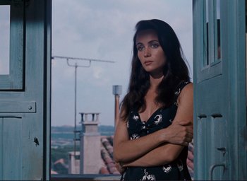 Movie still from “La Belle Noiseuse” (1991), directed by Jacques Rivette – A woman standing in front of an open window; Medium shot, Low angle