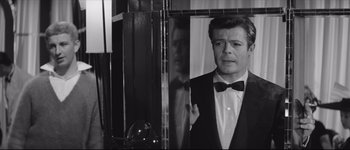 Movie still from “La Dolce Vita” (1960), directed by Federico Fellini – A black and white photo of a man in a tuxedo; Close Up shot, Over the shoulder angle