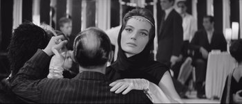 Movie still from “La Dolce Vita” (1960), directed by Federico Fellini – A woman wearing a headpiece and a black dress; Close Up shot, Over the shoulder angle