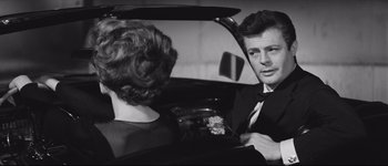 Movie still from “La Dolce Vita” (1960), directed by Federico Fellini – A man and a woman sitting in the back of a car; Medium shot, Over the shoulder angle