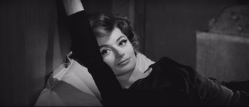 Movie still from “La Dolce Vita” (1960), directed by Federico Fellini – A black - and - white photo of a woman in a black dress; Close Up shot, High angle