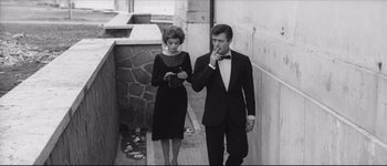 Movie still from “La Dolce Vita” (1960), directed by Federico Fellini – A man and a woman walking down a walkway; Medium shot, Low angle