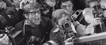 Movie still from “La Dolce Vita” (1960), directed by Federico Fellini – A black and white photo of a group of young men taking pictures; Close Up shot, High angle