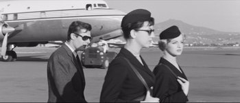 Movie still from “La Dolce Vita” (1960), directed by Federico Fellini – A black and white photo of three people in uniform; Medium shot, Low angle