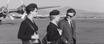 Movie still from “La Dolce Vita” (1960), directed by Federico Fellini – A group of people standing next to each other on a runway; Medium shot, Low angle