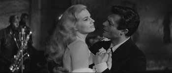 Movie still from “La Dolce Vita” (1960), directed by Federico Fellini – A man and a woman are posing for a picture; Close Up shot, Low angle