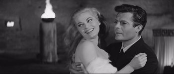 Movie still from “La Dolce Vita” (1960), directed by Federico Fellini – An old photo of a woman and a man smiling for the camera; Close Up shot, High angle