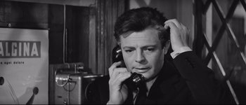Movie still from “La Dolce Vita” (1960), directed by Federico Fellini – A black and white photo of a man talking on a phone; Close Up shot, Low angle