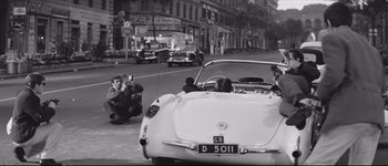 Movie still from “La Dolce Vita” (1960), directed by Federico Fellini – A man taking a picture of a man sitting in the back of a car; Wide shot, High angle