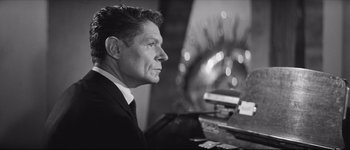 Movie still from “La Dolce Vita” (1960), directed by Federico Fellini – Black and white photograph of a man in a suit; Close Up shot, Low angle