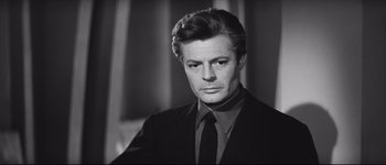 Movie still from “La Dolce Vita” (1960), directed by Federico Fellini – Black and white photograph of a man wearing a suit; Close Up shot, Low angle