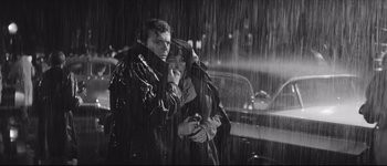 Movie still from “La Dolce Vita” (1960), directed by Federico Fellini – A man and a woman standing in the pouring rain; Medium shot, High angle