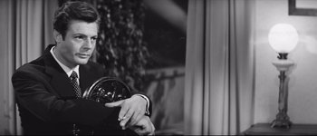 Movie still from “La Dolce Vita” (1960), directed by Federico Fellini – A black - and - white photo of a man in a suit; Medium shot, Over the shoulder angle