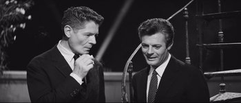 Movie still from “La Dolce Vita” (1960), directed by Federico Fellini – A black and white photo of two men in suits; Medium shot, Over the shoulder angle