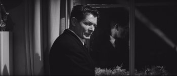 Movie still from “La Dolce Vita” (1960), directed by Federico Fellini – A black and white photo of a man in front of a mirror; Close Up shot, Over the shoulder angle