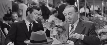 Movie still from “La Dolce Vita” (1960), directed by Federico Fellini – Two men sitting at a table in front of each other; Medium shot, Over the shoulder angle
