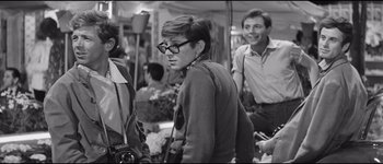 Movie still from “La Dolce Vita” (1960), directed by Federico Fellini – A group of young men standing next to each other; Medium shot, Over the shoulder angle