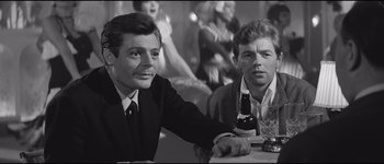 Movie still from “La Dolce Vita” (1960), directed by Federico Fellini – Two men sitting at a table with a beer; Medium shot, Over the shoulder angle