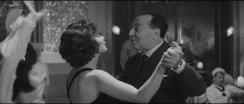 Movie still from “La Dolce Vita” (1960), directed by Federico Fellini – An older man and a young woman dancing together; Medium shot, Low angle