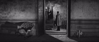 Movie still from “La Dolce Vita” (1960), directed by Federico Fellini – A man standing in front of a mirror in a room; Wide shot, High angle