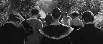 Movie still from “La Dolce Vita” (1960), directed by Federico Fellini – A group of people walking down a street; Medium shot, Over the shoulder angle