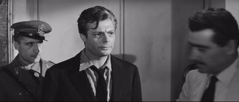 Movie still from “La Dolce Vita” (1960), directed by Federico Fellini – Black and white photograph of a man wearing a suit and tie; Close Up shot, Over the shoulder angle