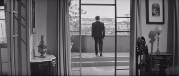 Movie still from “La Dolce Vita” (1960), directed by Federico Fellini – A black and white photo of a man looking out of a window; Wide shot, Low angle