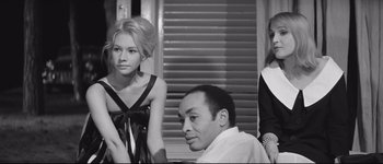 Movie still from “La Dolce Vita” (1960), directed by Federico Fellini – A black and white photo of a man and two women; Medium shot, Low angle