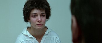 Movie still from “Nikita” (1990), directed by Luc Besson – A woman looking into a mirror while sitting down; Close Up shot, Over the shoulder angle