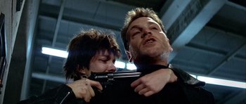 Movie still from “Nikita” (1990), directed by Luc Besson – A man and a woman holding a gun in their hands; Close Up shot, Low angle