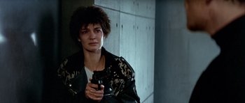 Movie still from “Nikita” (1990), directed by Luc Besson – A person holding a gun in a room; Close Up shot, Low angle