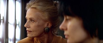 Movie still from “Nikita” (1990), directed by Luc Besson – A woman and a man are sitting next to each other; Close Up shot, Over the shoulder angle