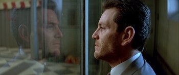 Movie still from “Nikita” (1990), directed by Luc Besson – A person looking out a window; Close Up shot, Low angle