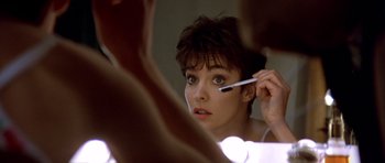 Movie still from “Nikita” (1990), directed by Luc Besson – A woman is looking in the mirror while brushing her teeth; Close Up shot, Over the shoulder angle