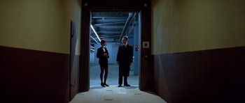 Movie still from “Nikita” (1990), directed by Luc Besson – A man and a woman standing in an open door; Wide shot, Low angle