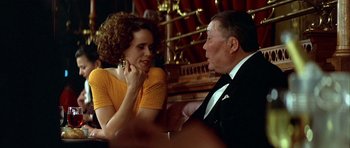 Movie still from “Nikita” (1990), directed by Luc Besson – An older man and a young woman are sitting at a table; Close Up shot, Over the shoulder angle